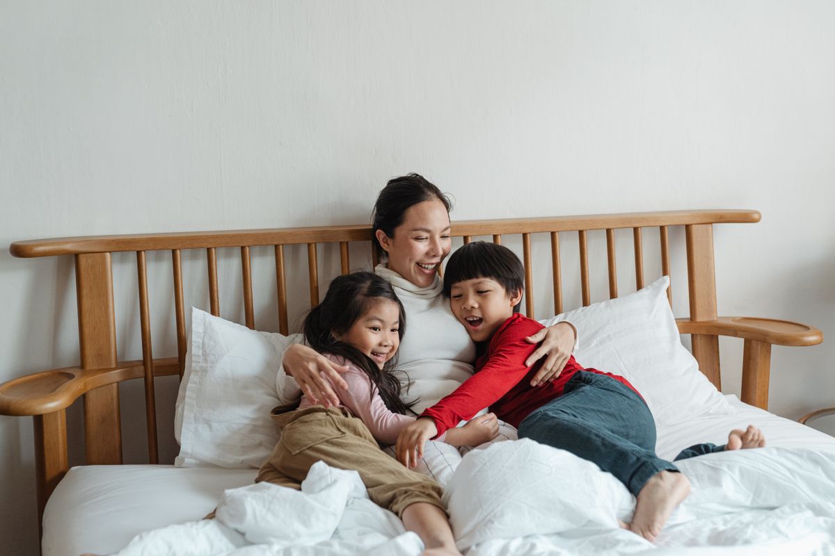 A mother and her two children cuddled up at bedtime